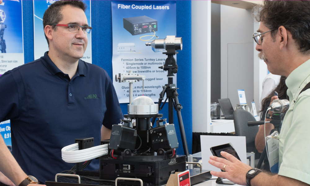 Attendees greet an exhibitor in his attractive booth space
