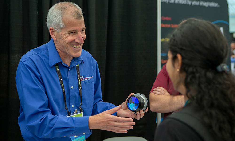 Exhibitor shows his product to an interested researcher at the Sensors + Imaging exhibition