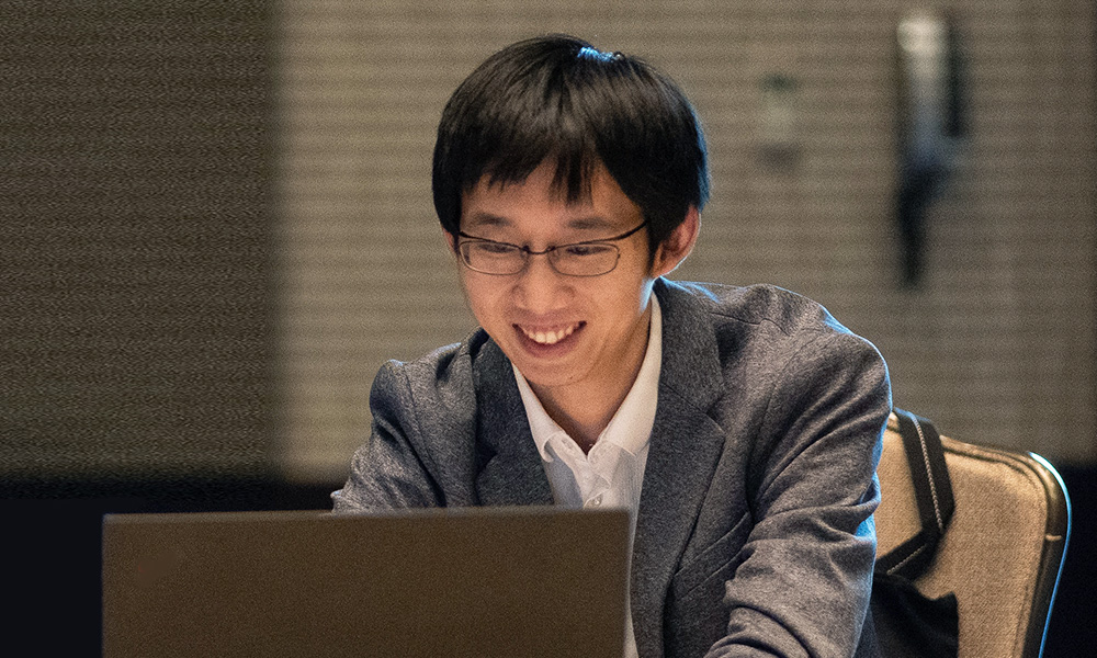 An author sits in front of a laptop to registers for a SPIE event