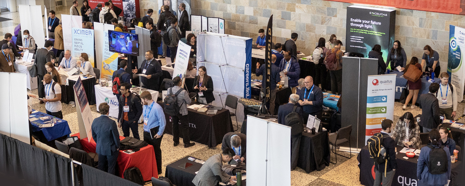 Attendees gather around booths at an SPIE Job Fair