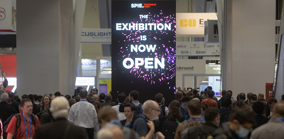 SPIE Photonics West Exhibit Now Open sign with crowd in 2023.