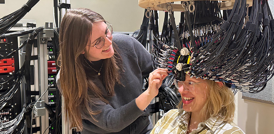 2025 SPIE-Franz Hillenkamp Postdoctoral Fellow Morgan Fogarty adjusts the very high-density diffuse optical tomography (VHD-DOT) cap on labmate Wiete Fehner, ensuring optimal optode coupling and participant comfort as a critical step before data collection.