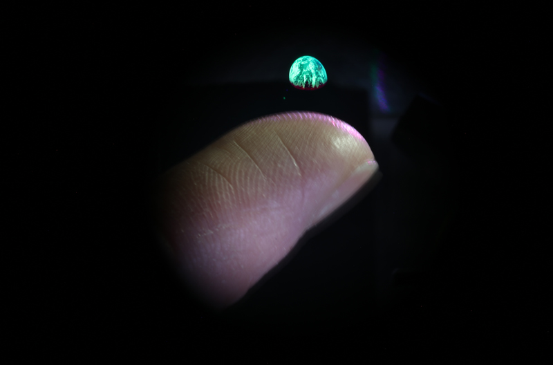 Optical Trap Display (OTD) image of the Earth above a finger tip